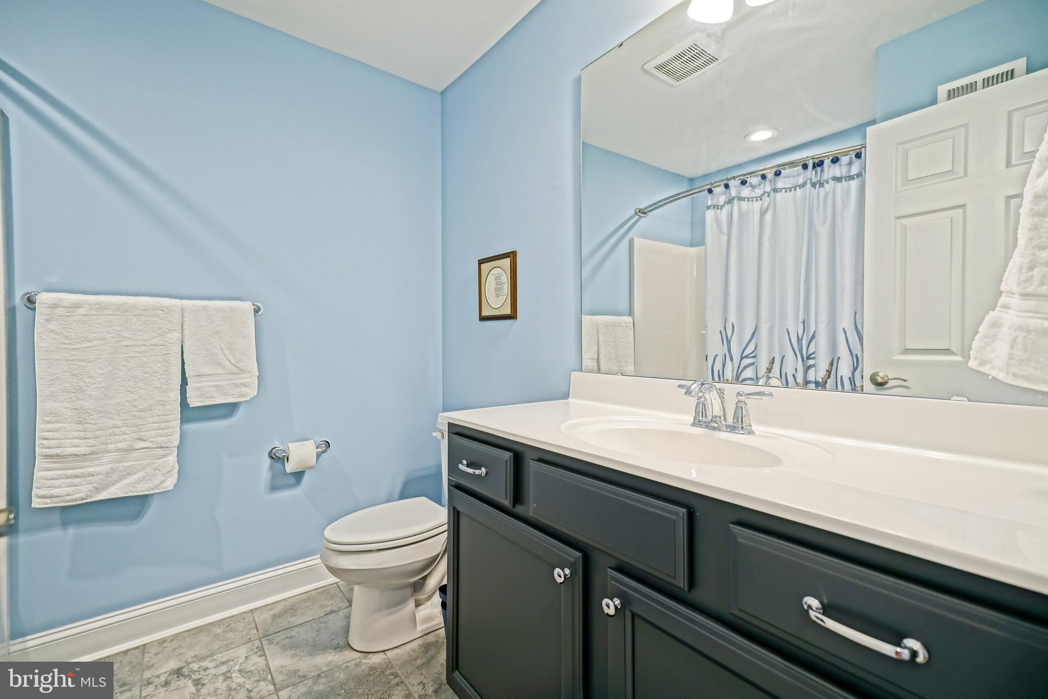 31301 Temple Road Lewes, DE 19958 - Photo 45 of 64 a bathroom with a granite countertop sink a toilet and a mirror