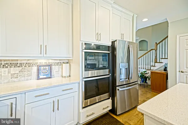 a kitchen with white cabinets and appliances