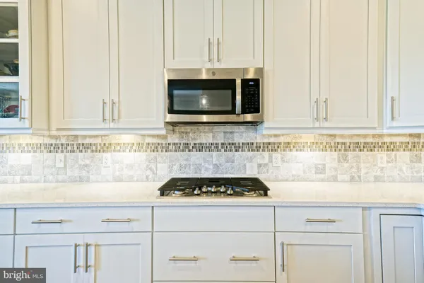a kitchen with stainless steel appliances kitchen island granite countertop furniture and a refrigerator