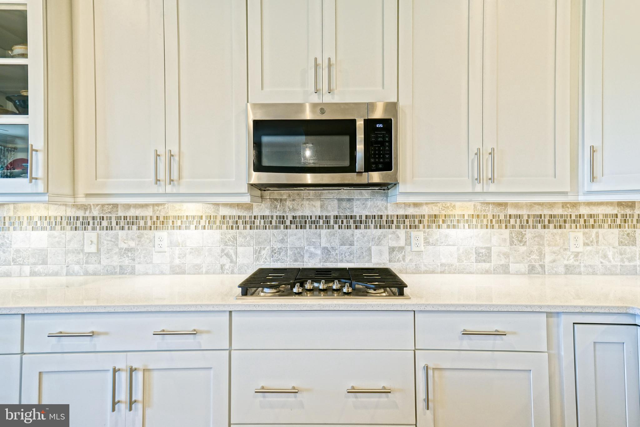 31301 Temple Road Lewes, DE 19958 - Photo 9 of 64 a kitchen with white cabinets and appliances