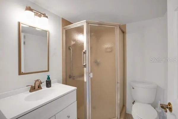 a bathroom with a toilet sink vanity and mirror