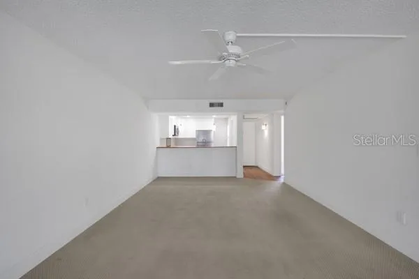 a view of a kitchen and an empty room