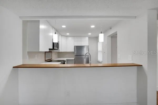 a large kitchen with stainless steel appliances a sink and a stove top oven