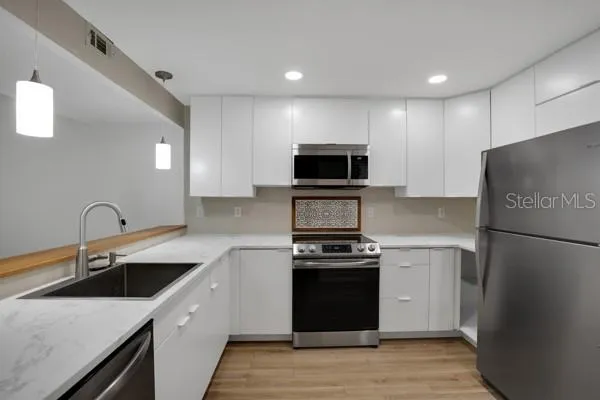 a kitchen with a sink appliances and cabinets