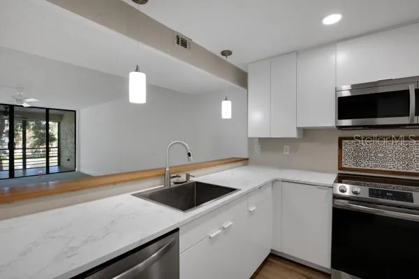 a kitchen with a sink and stainless steel appliances
