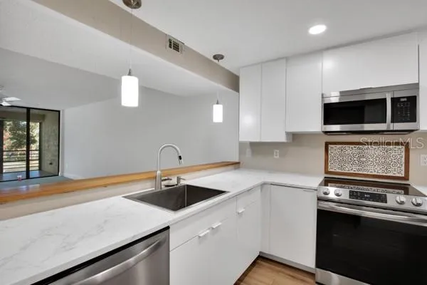 a kitchen with a sink and stainless steel appliances