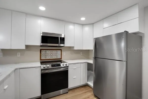 a kitchen with a refrigerator stove and microwave