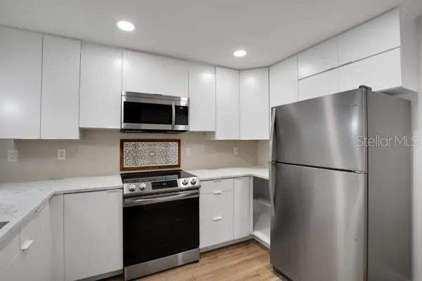 a kitchen with a refrigerator stove and microwave