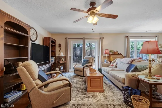 a living room with furniture a flat screen tv and a large window
