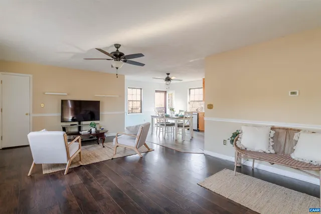 a living room with furniture and a flat screen tv with wooden floor