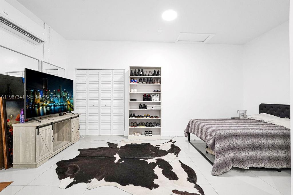 12735 Southwest 211th Street Miami, FL 33177 - Photo 29 of 34 a bedroom with a bed and a flat screen tv
