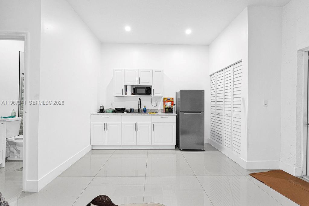 12735 Southwest 211th Street Miami, FL 33177 - Photo 30 of 34 a kitchen with a refrigerator and white cabinets