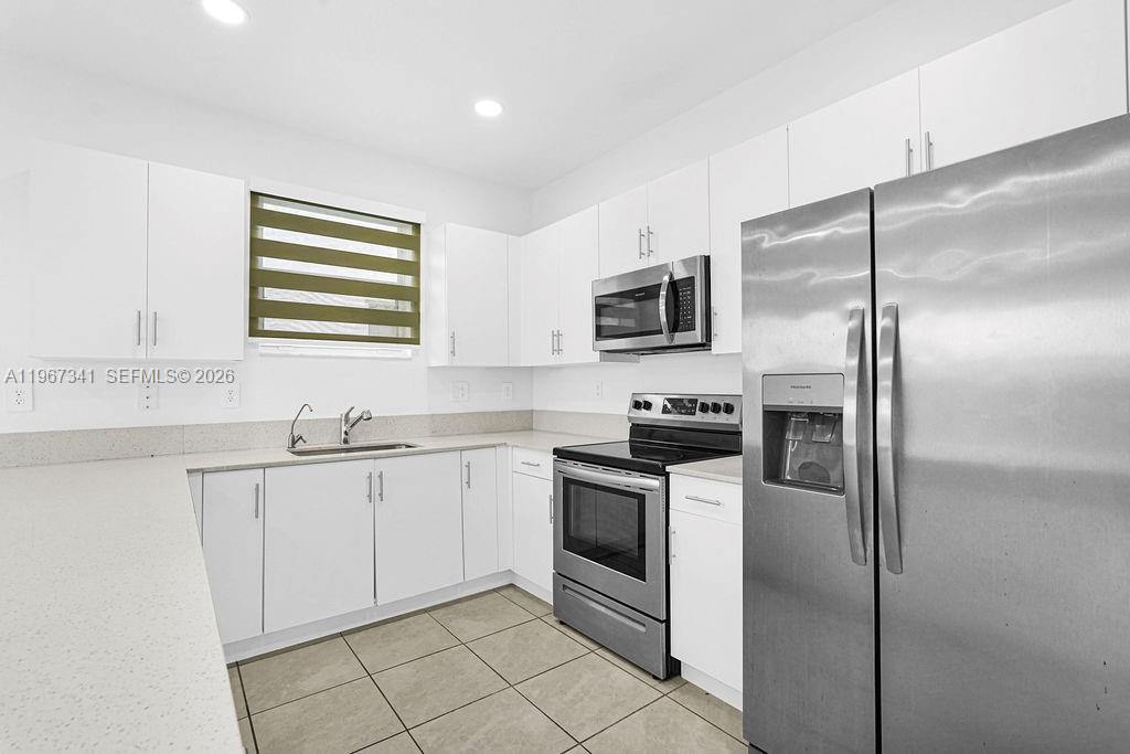 12735 Southwest 211th Street Miami, FL 33177 - Photo 3 of 34 a kitchen with stainless steel appliances granite countertop a refrigerator and a sink