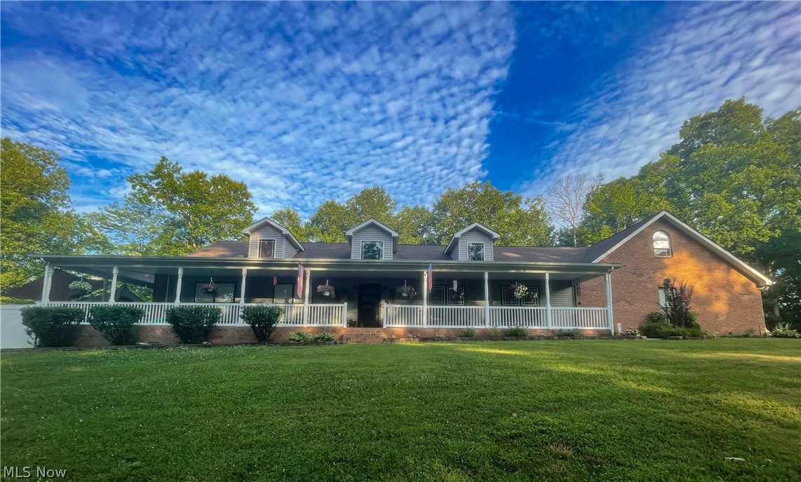 View of front of home featuring covered porch and a front lawn