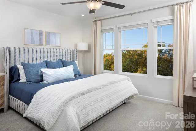 a large bed sitting in a bedroom next to a window