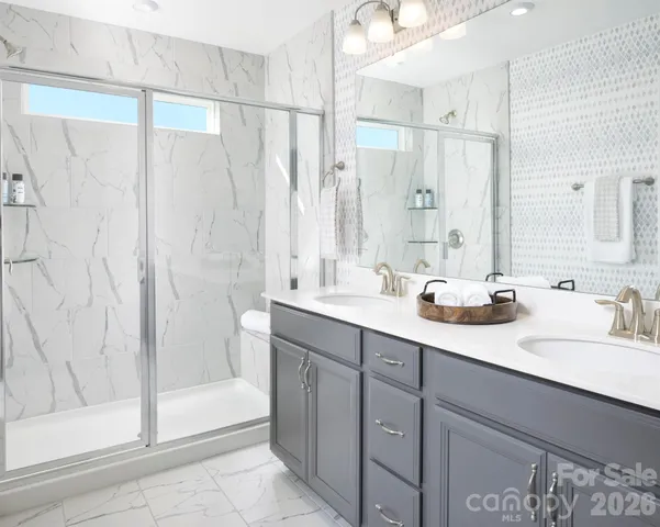 a bathroom with a double vanity sink mirror and shower