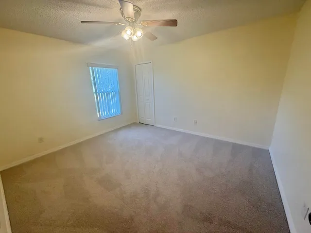 en empty room with windows and fan