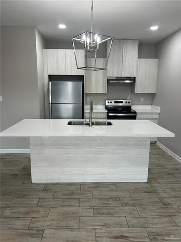 a kitchen with stainless steel appliances a stove refrigerator and microwave