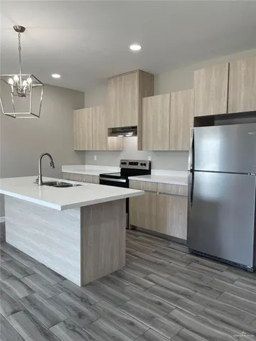 a kitchen with a refrigerator a sink and cabinets