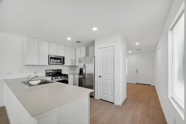 a kitchen with stainless steel appliances a refrigerator sink and microwave