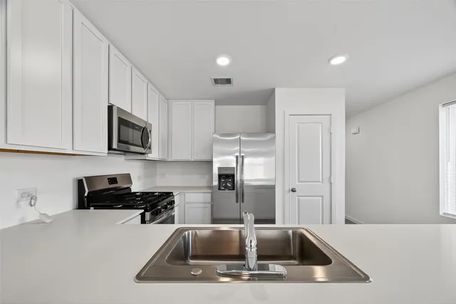 a kitchen that has a sink a microwave and cabinets