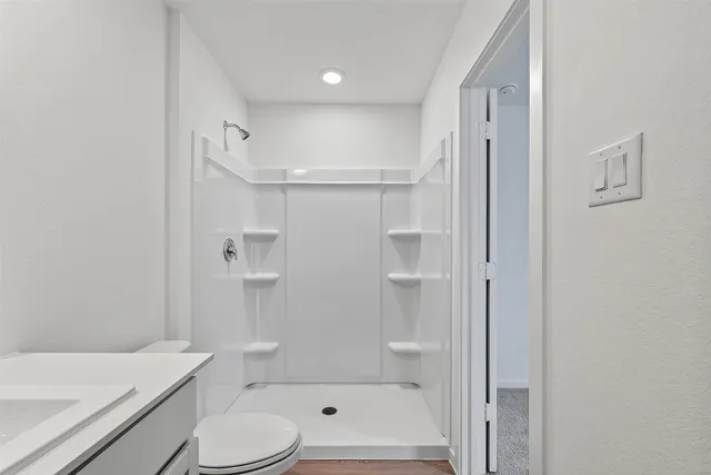 a bathroom with a shower a toilet and a bathtub