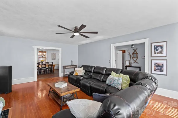 a dining room with furniture a chandelier and wooden floor