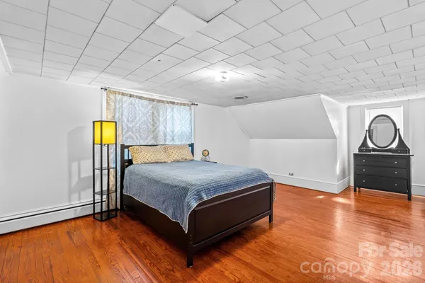 a bedroom with a bed and painting on the wall