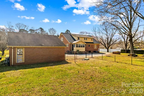 a view of a yard with wooden fence