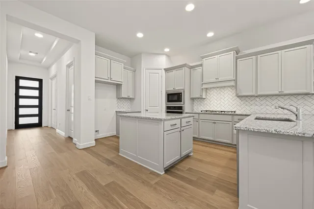 a kitchen with granite countertop a white stove top oven and white cabinets