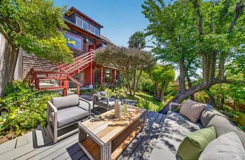 a view of a patio with couches table and chairs and potted plants
