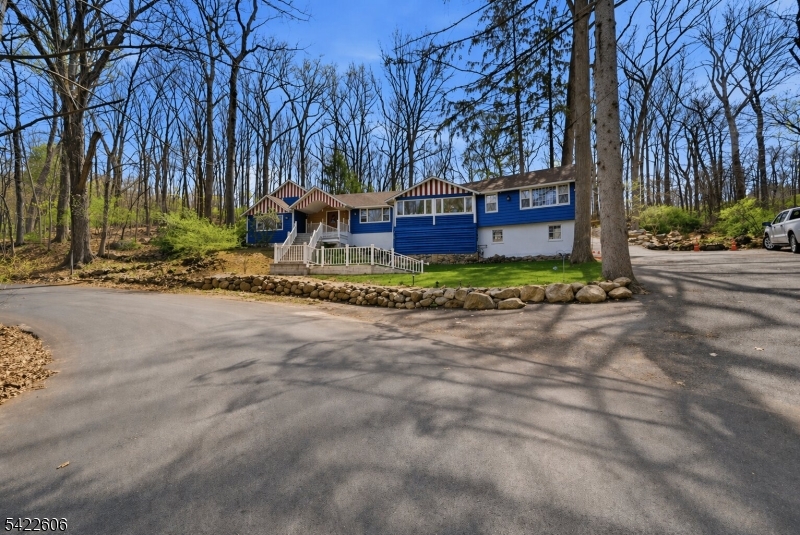 a view of a house with a yard and large trees
