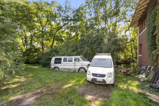 a white house with a big yard and large trees