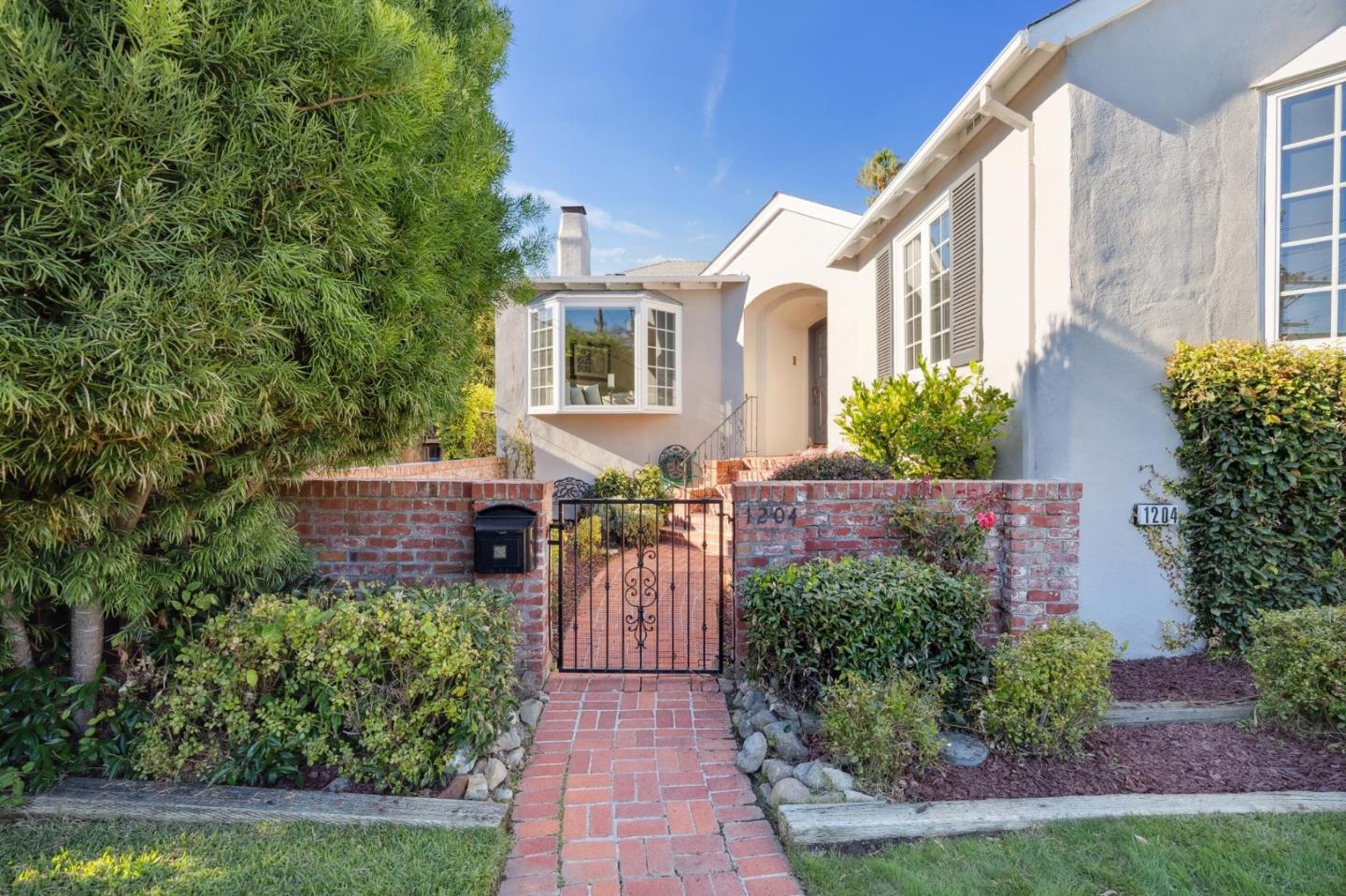 1204 Edgehill Drive Burlingame, CA 94010 - Photo 3 of 38 a front view of a house with a yard and potted plants