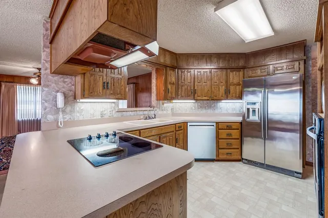 a kitchen with stainless steel appliances granite countertop a sink a stove and a refrigerator