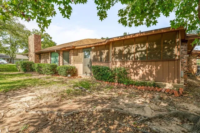 a view of swimming pool with lawn chairs and large trees