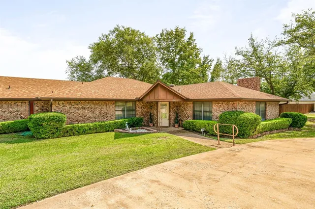 a view of a house with a yard and sitting area