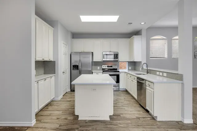 a kitchen with stainless steel appliances granite countertop a sink stove and microwave