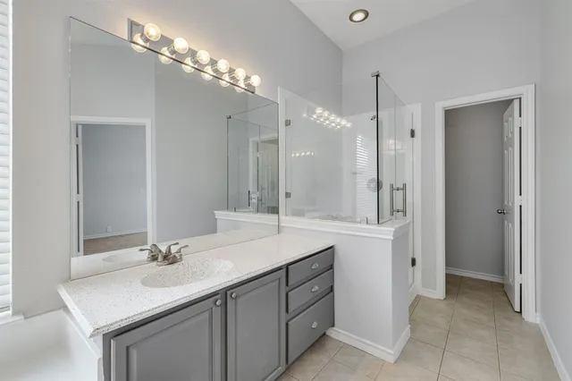 a bathroom with a granite countertop sink mirror and a bathtub