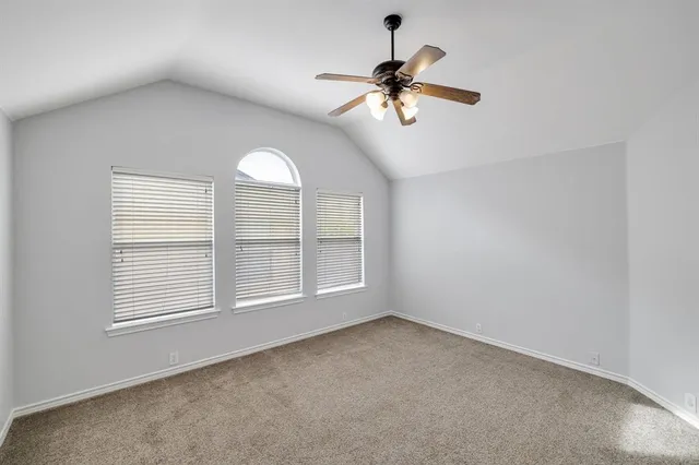 a view of an empty room and a kitchen