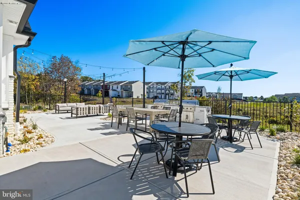 a view of a patio with a dining table and chairs under an umbrella