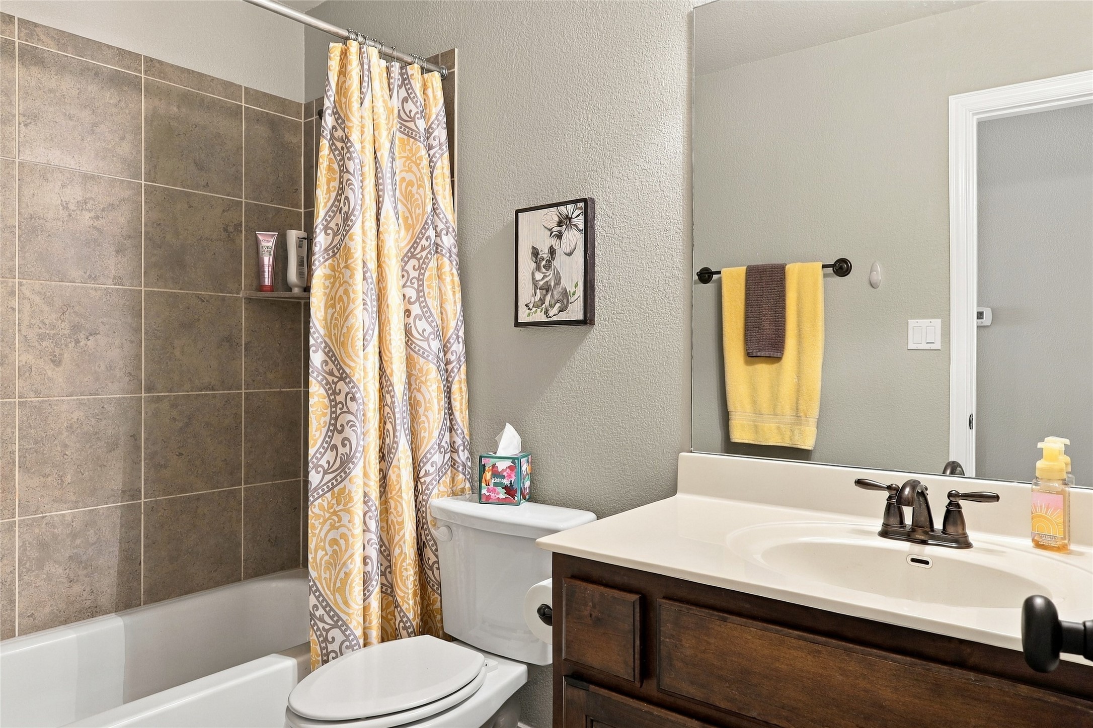 320 Fort Cobb Way Georgetown, TX 78628 - Photo 17 of 37 Tiled tub surround paired with a dark wood vanity creates a warm, classic feel.
