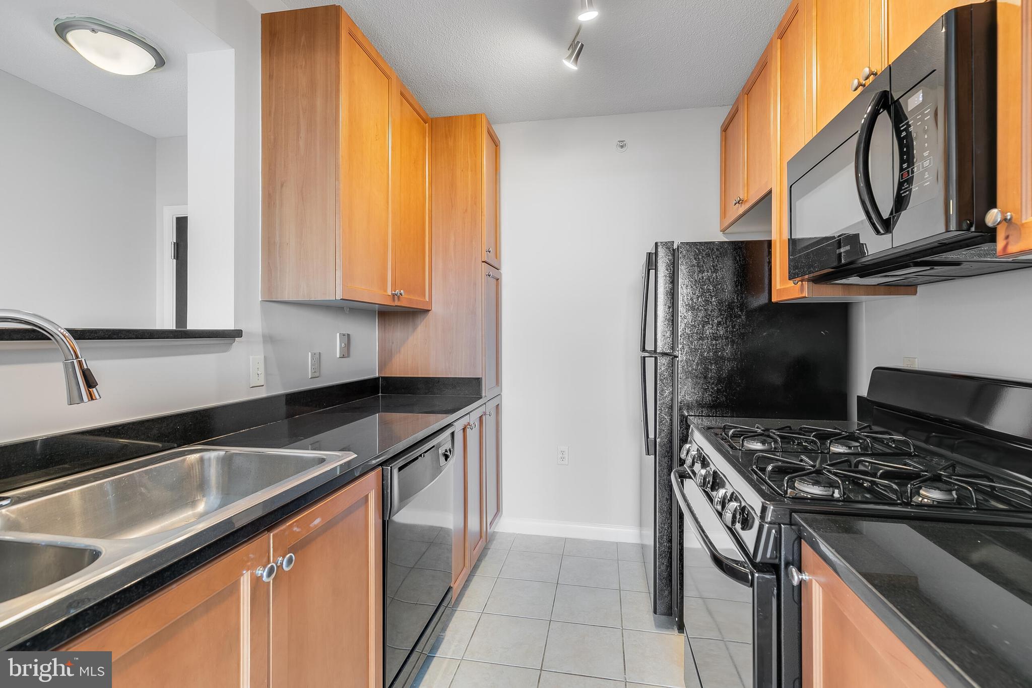 851 North Glebe Road, Unit 1413 Arlington, VA 22203 - Photo 8 of 33 a kitchen with stainless steel appliances granite countertop a sink stove and refrigerator