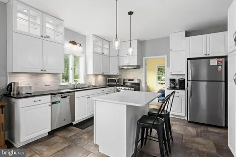 a kitchen with refrigerator a white table and chairs