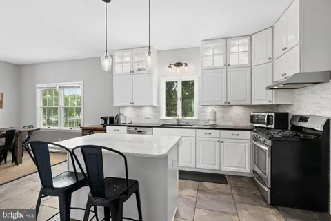 a kitchen with stainless steel appliances granite countertop a stove a sink a microwave and a refrigerator