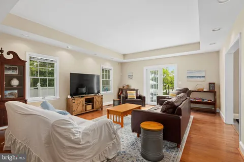 a living room with furniture a flat screen tv and a window