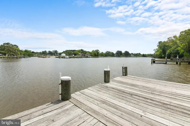a view of swimming pool with lawn chairs under an umbrella