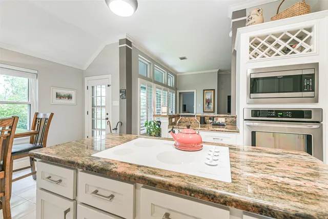 a kitchen with granite countertop a stove and cabinets