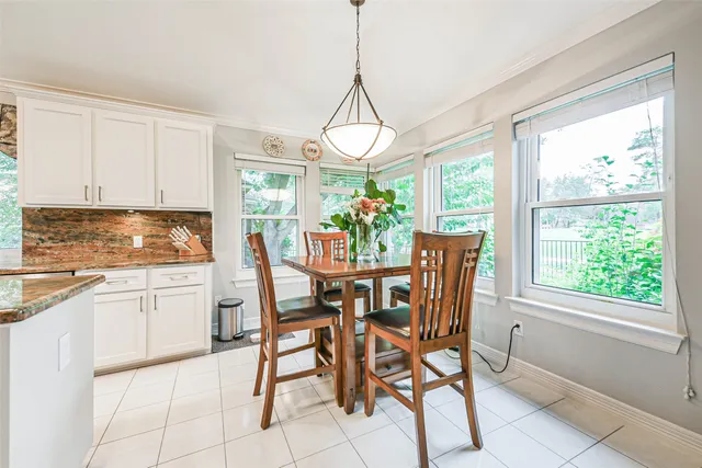 a dining room filled chandelier and kitchen view