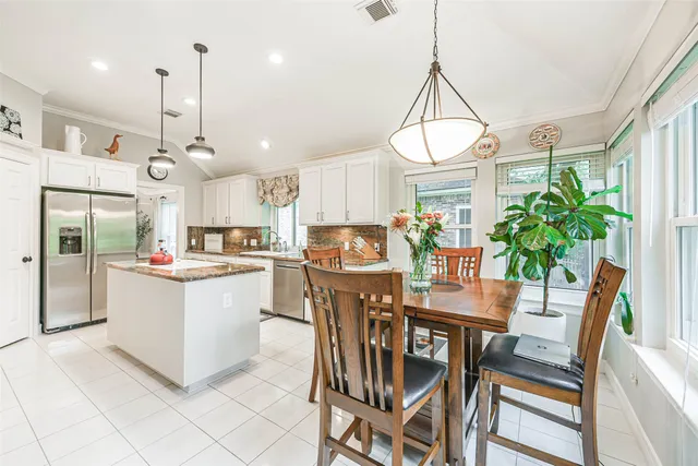a kitchen with granite countertop a table chairs stove and cabinets